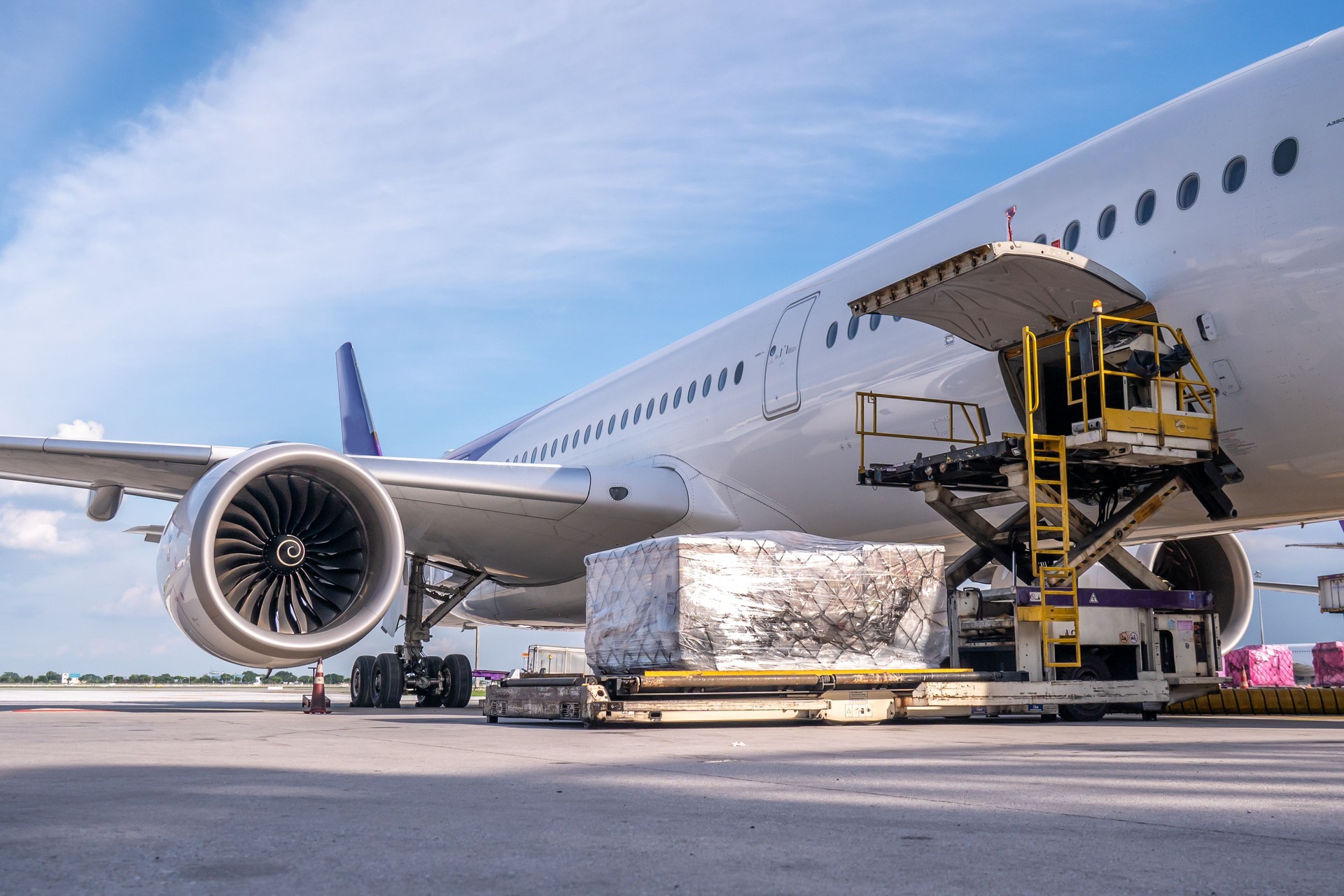 Air cargo logistic containers are loading to an airplane.